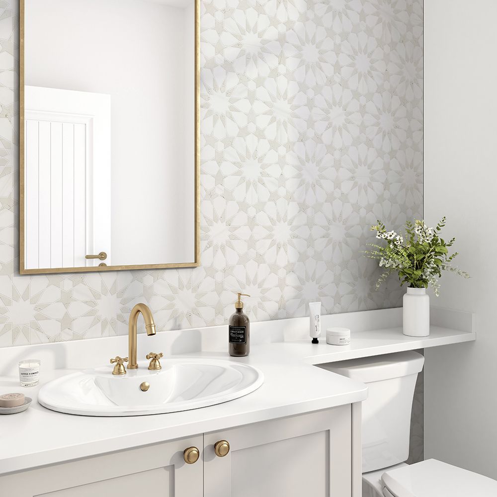 Bathroom with floral patterned wallpaper, gold faucet, white sink, and cabinet.