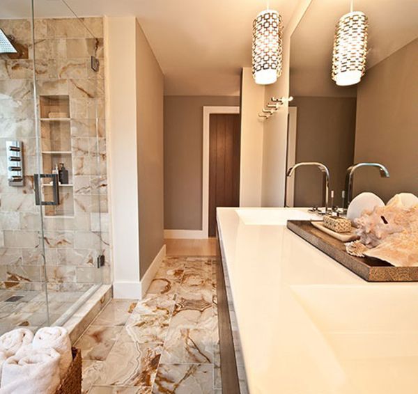 Elegant bathroom with stone shower, long vanity, and decorative pendant lights.
