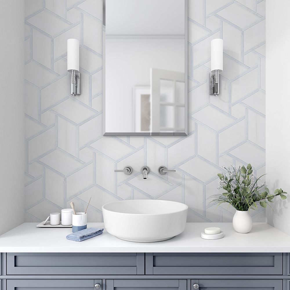Bathroom with geometric tile backsplash, vessel sink, mirror, and two sconces. Gray vanity.