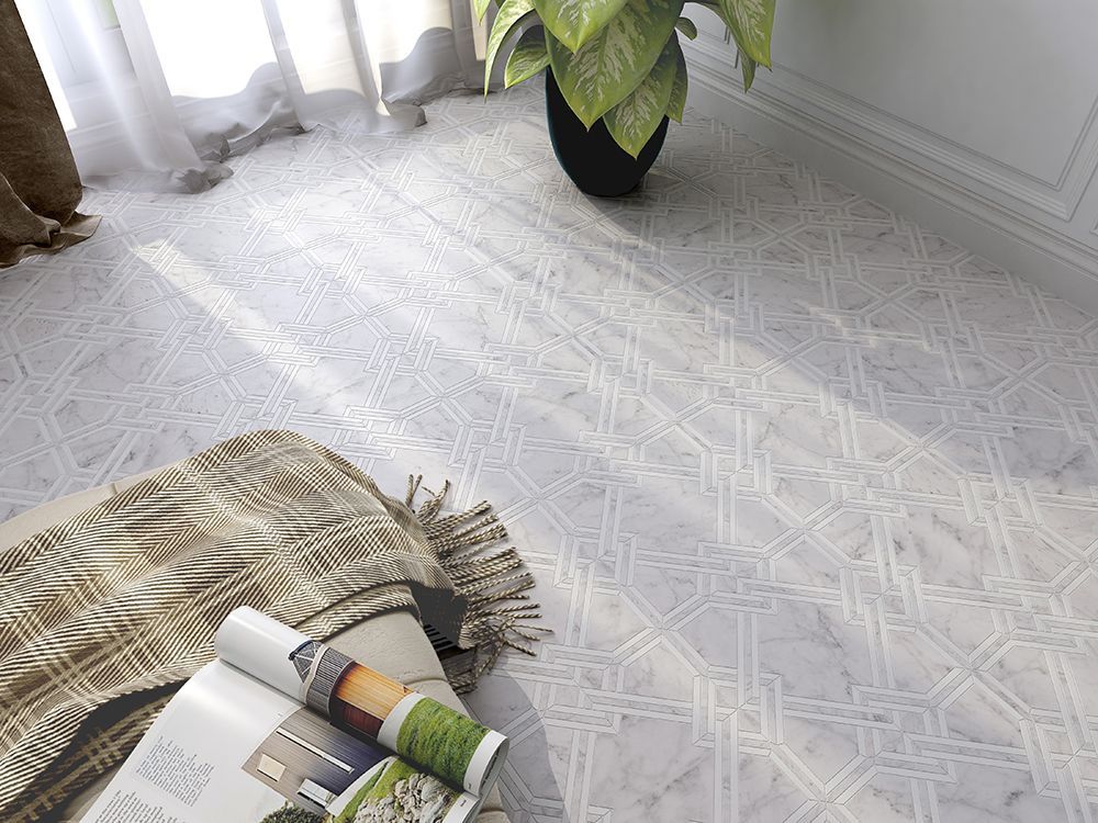 Floor with intricate geometric tile design, blanket, open magazine, and potted plant.