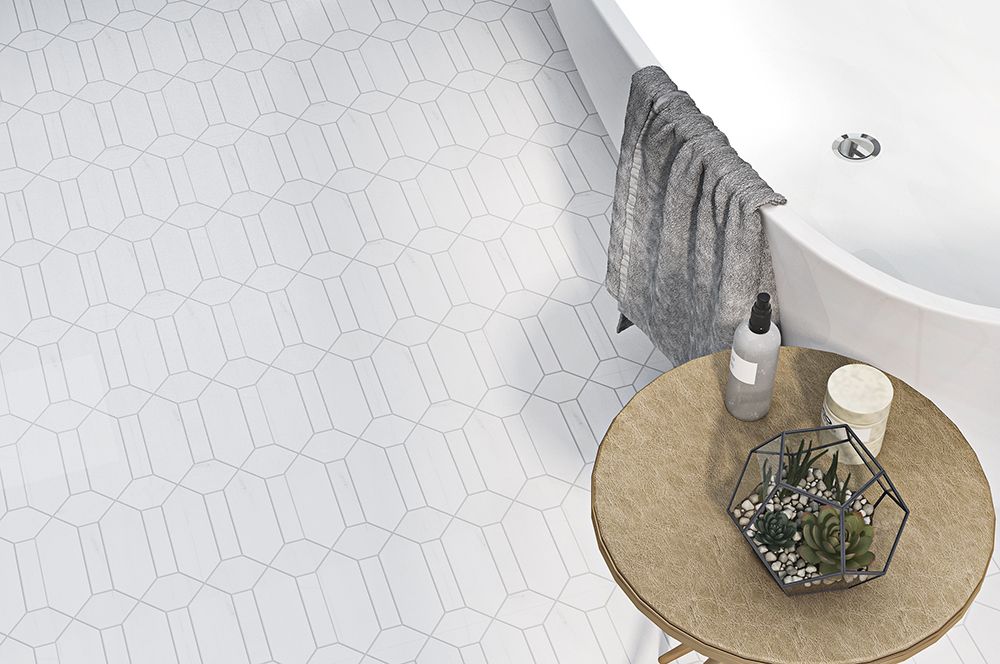 White bathroom with patterned floor, bathtub, side table, and towel.