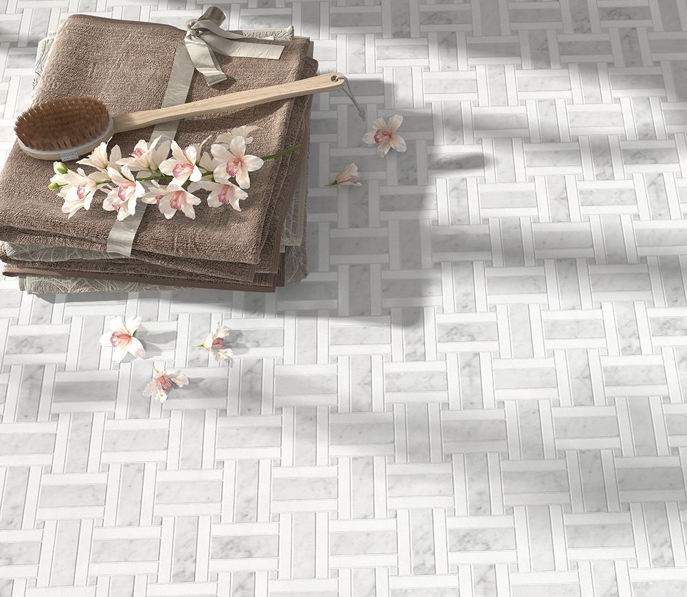 Stack of brown towels with flowers and a wooden brush on a woven-patterned white marble floor.