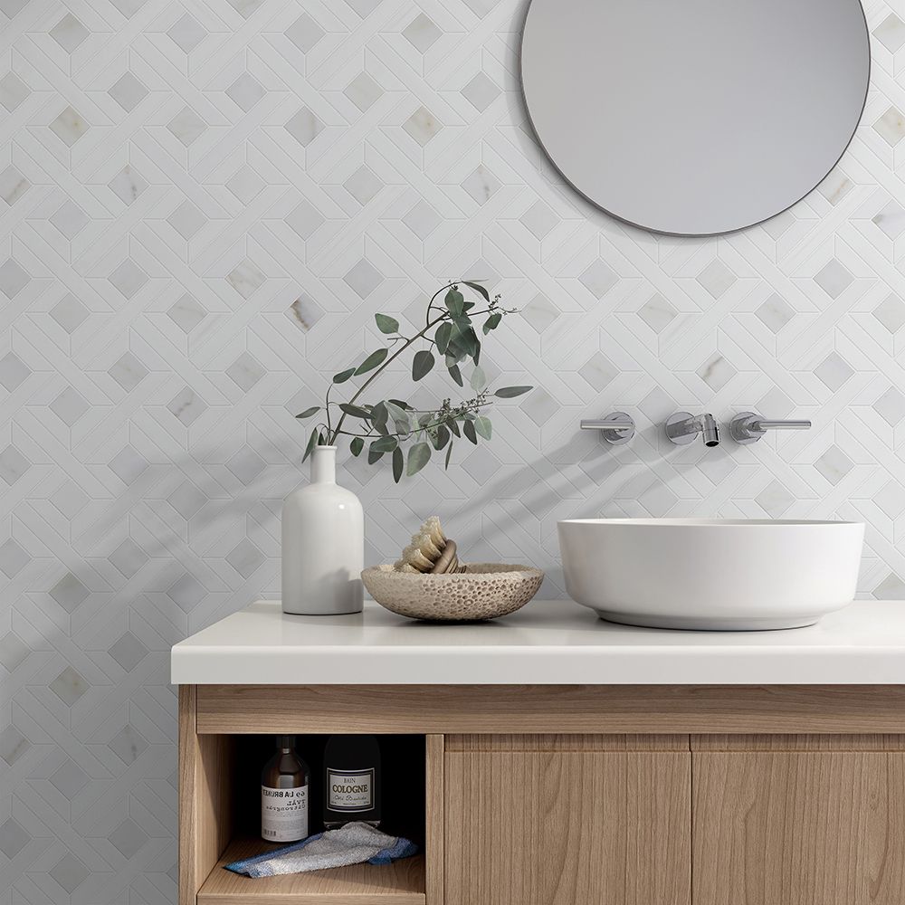 Bathroom with geometric patterned tile, wood vanity, vessel sink, round mirror, and decorative elements.