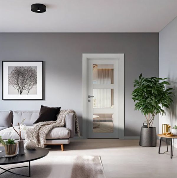 Living room with gray walls, sofa, framed art, and glass door. A potted plant stands near the door.