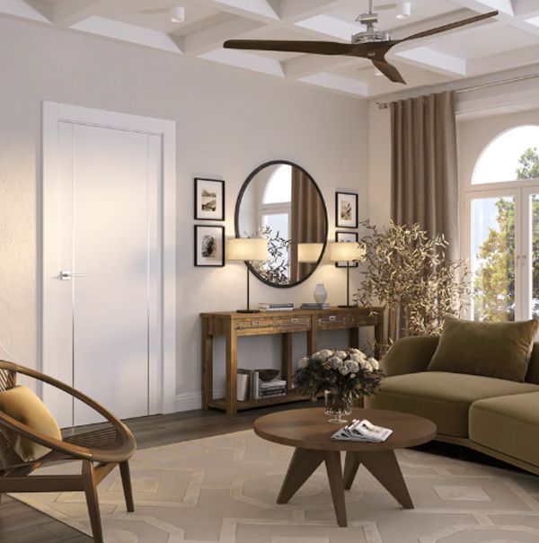 Living room with round mirror, sofa, and wooden furniture; neutral tones.
