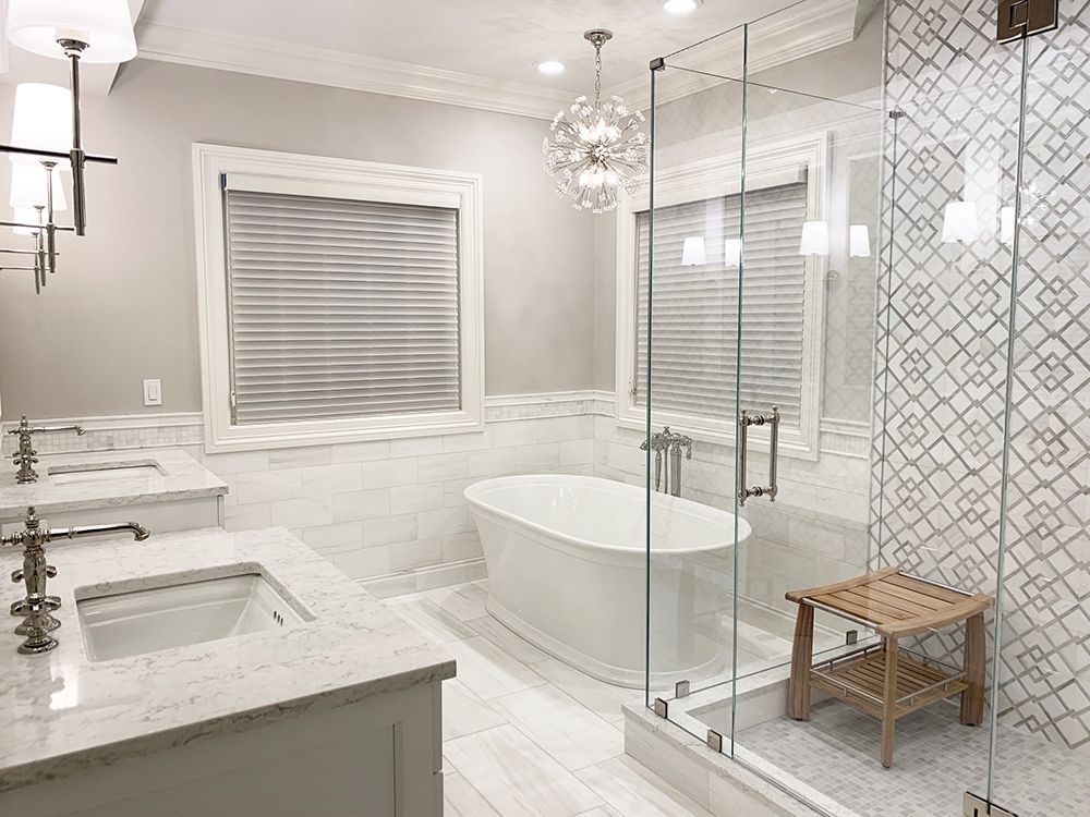 Luxurious bathroom with a freestanding tub, glass shower, and marble tile.
