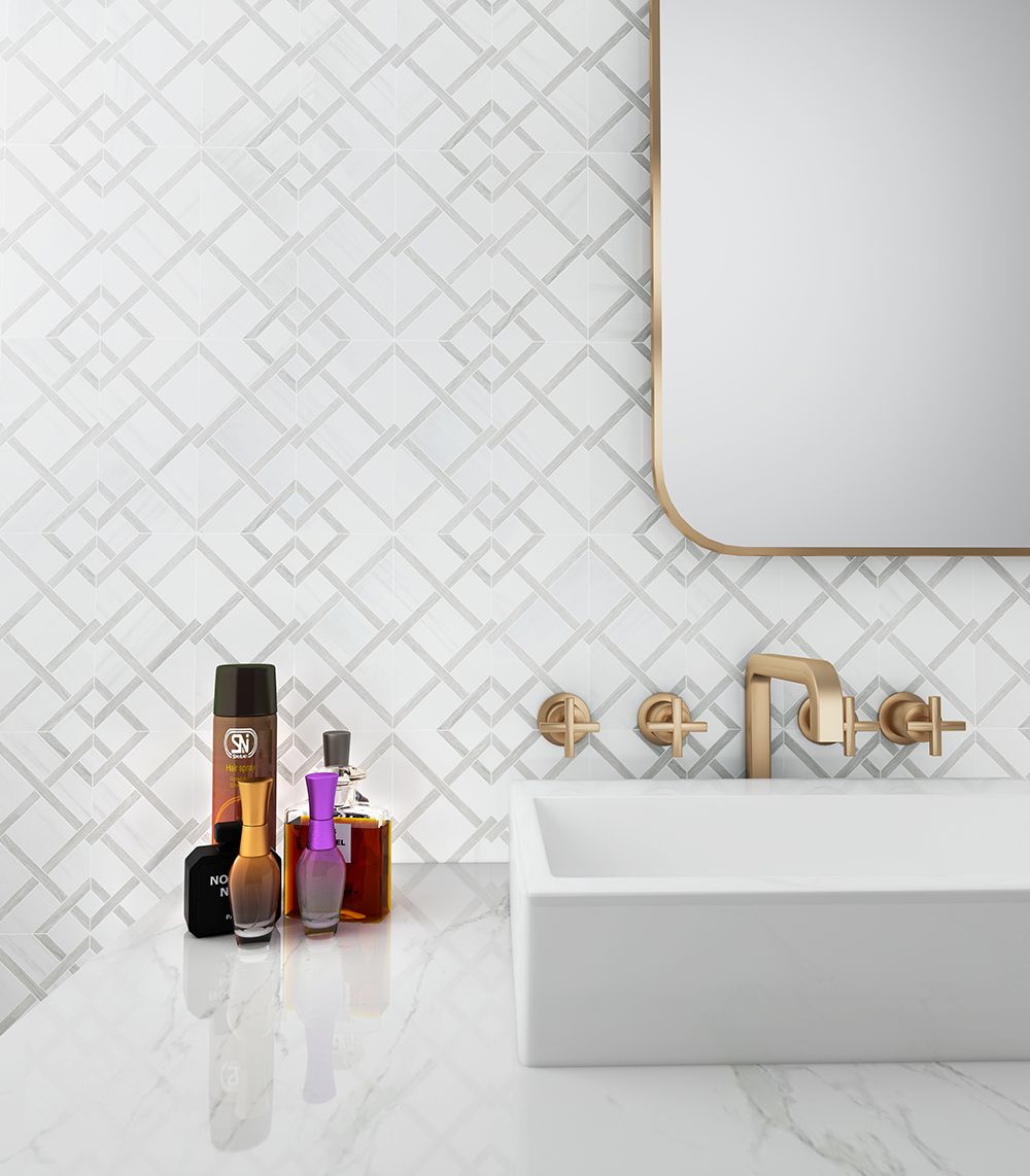Bathroom with white square sink, gold fixtures, marble countertop, patterned white tile backsplash, and mirror.