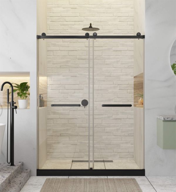 Glass shower with black sliding door frame and fixtures, set against brick-like wall tiles.