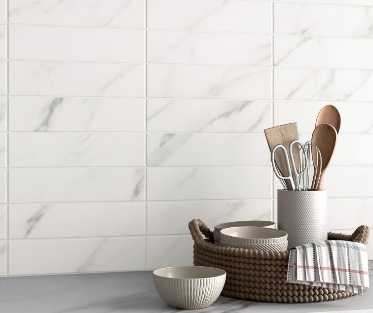 White marble tile backsplash behind kitchen accessories.