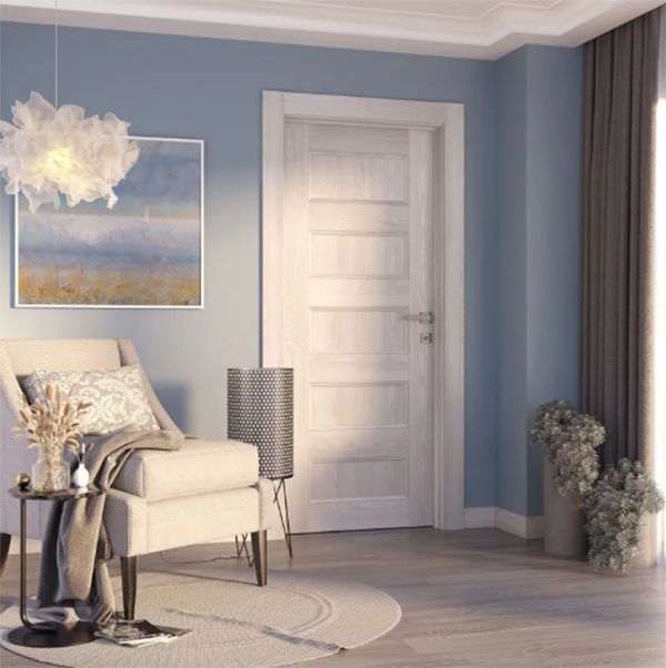 Cozy room with blue walls, white door, armchair, artwork, and a fluffy pendant light.
