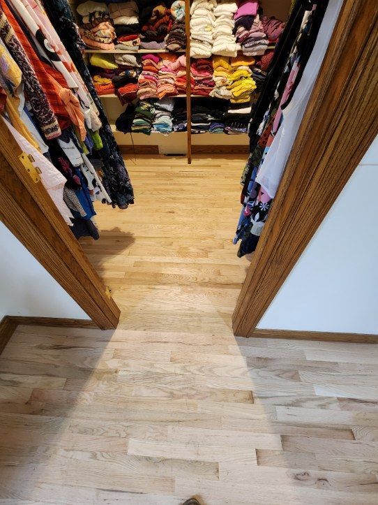 Open closet with colorful folded clothes and hanging garments on shelves and racks