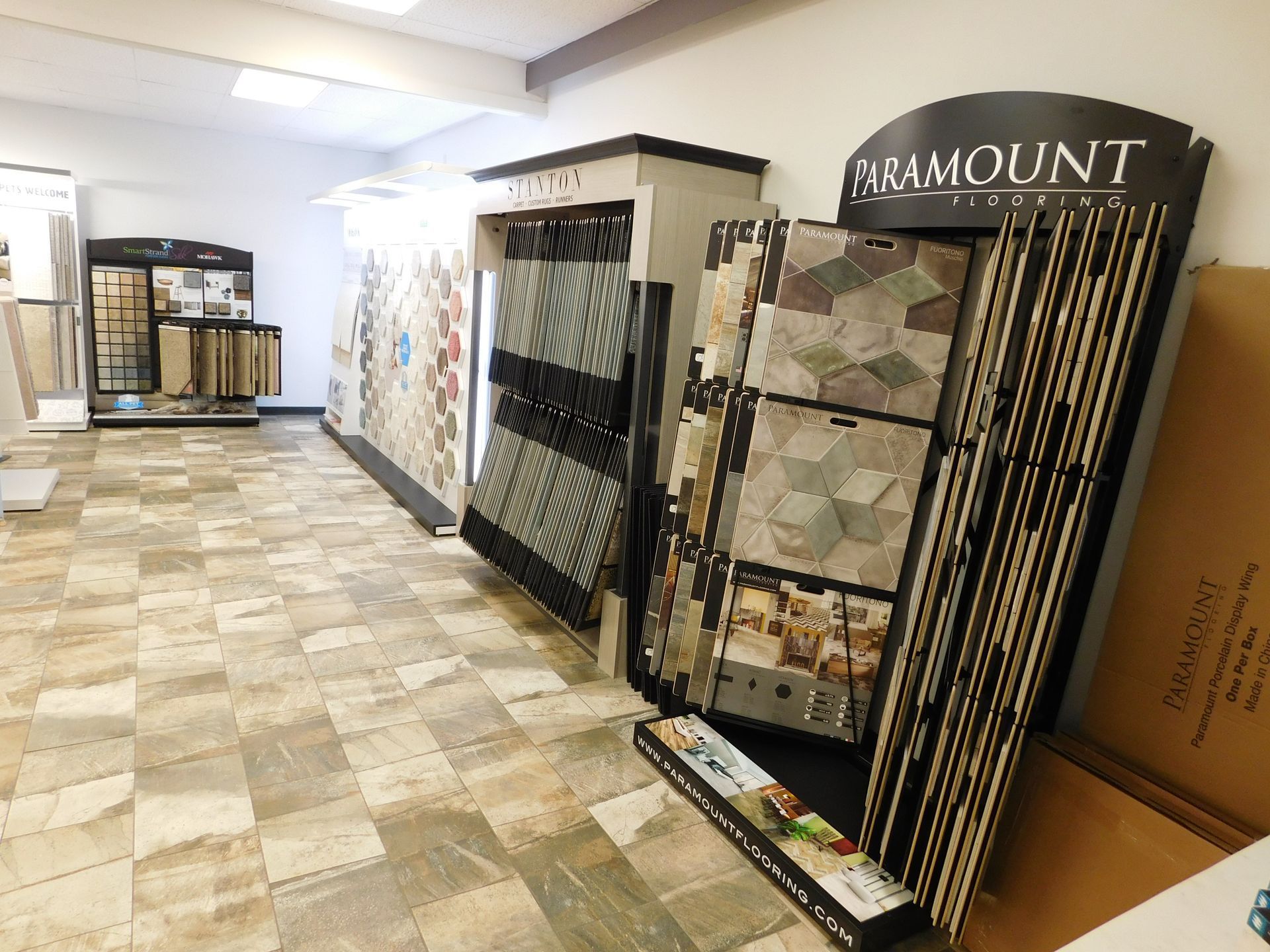 Showroom with large floor tile and carpet sample displays, including a Paramount sample rack.