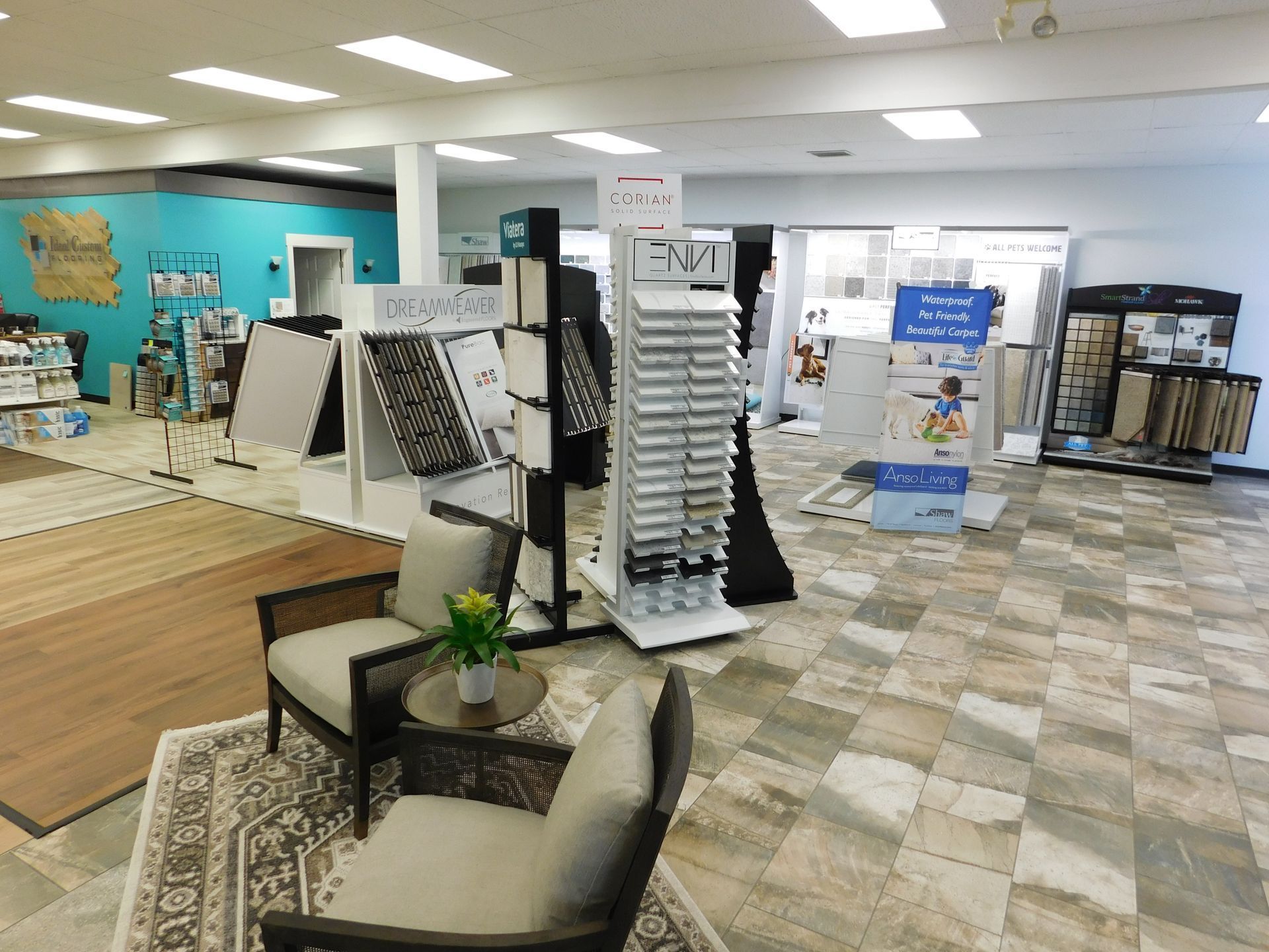 Bright showroom interior with flooring displays, sample racks, rugs, and seating area