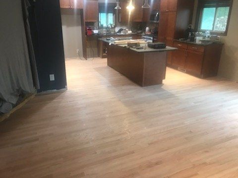 Modern kitchen with large island, dark wood cabinets, and light hardwood floors