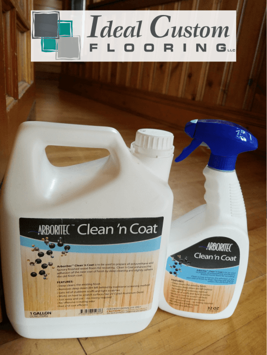 Cleaning products on a wood floor with an “Ideal Custom Flooring” sign in the background