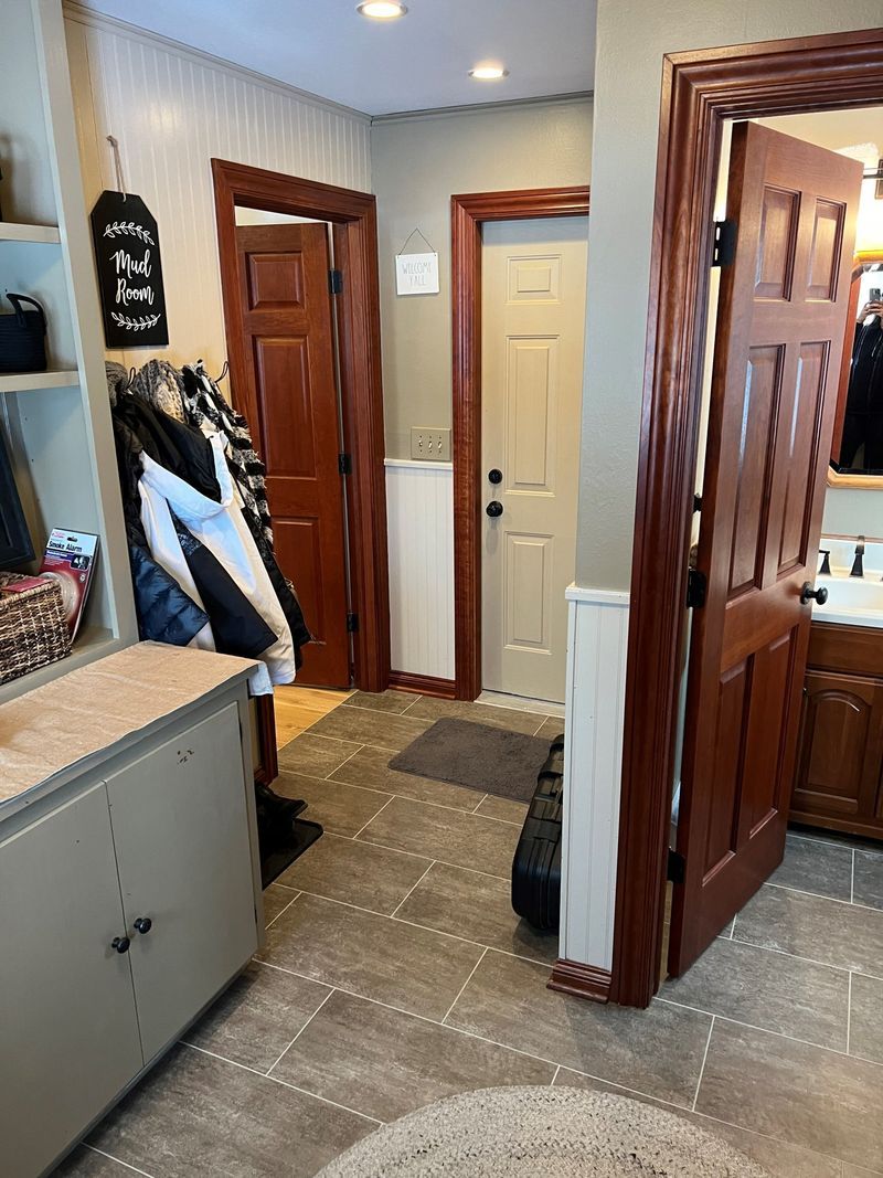 Hallway with multiple wooden doors, carpet runner, and a closet door ajar in a home interior.