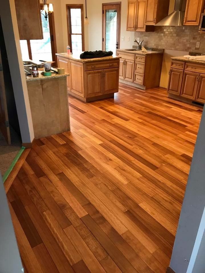 Empty kitchen with glossy wood floors and light wood cabinets