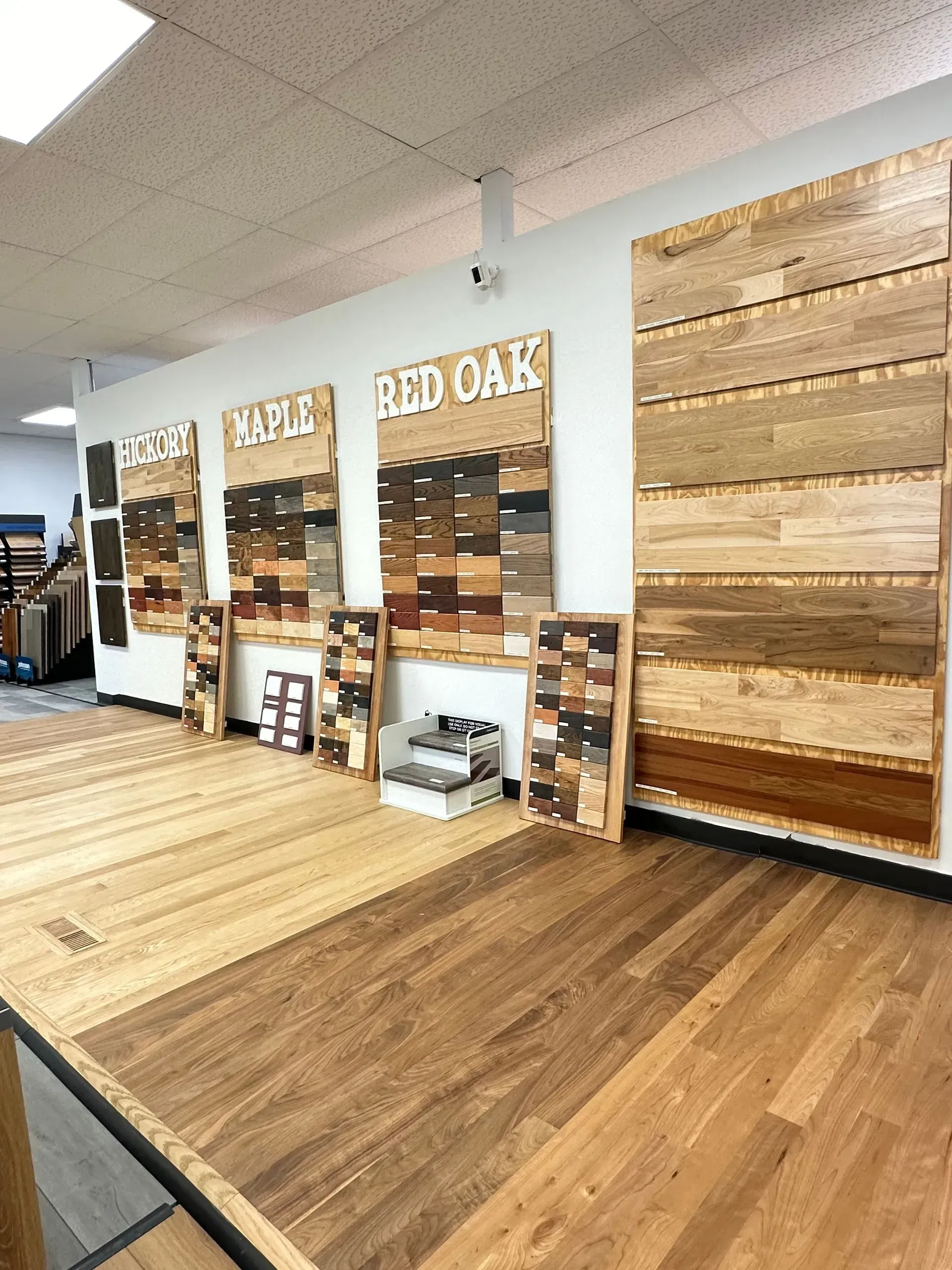 Flooring showroom with wood sample boards labeled White Oak and Red Oak on display