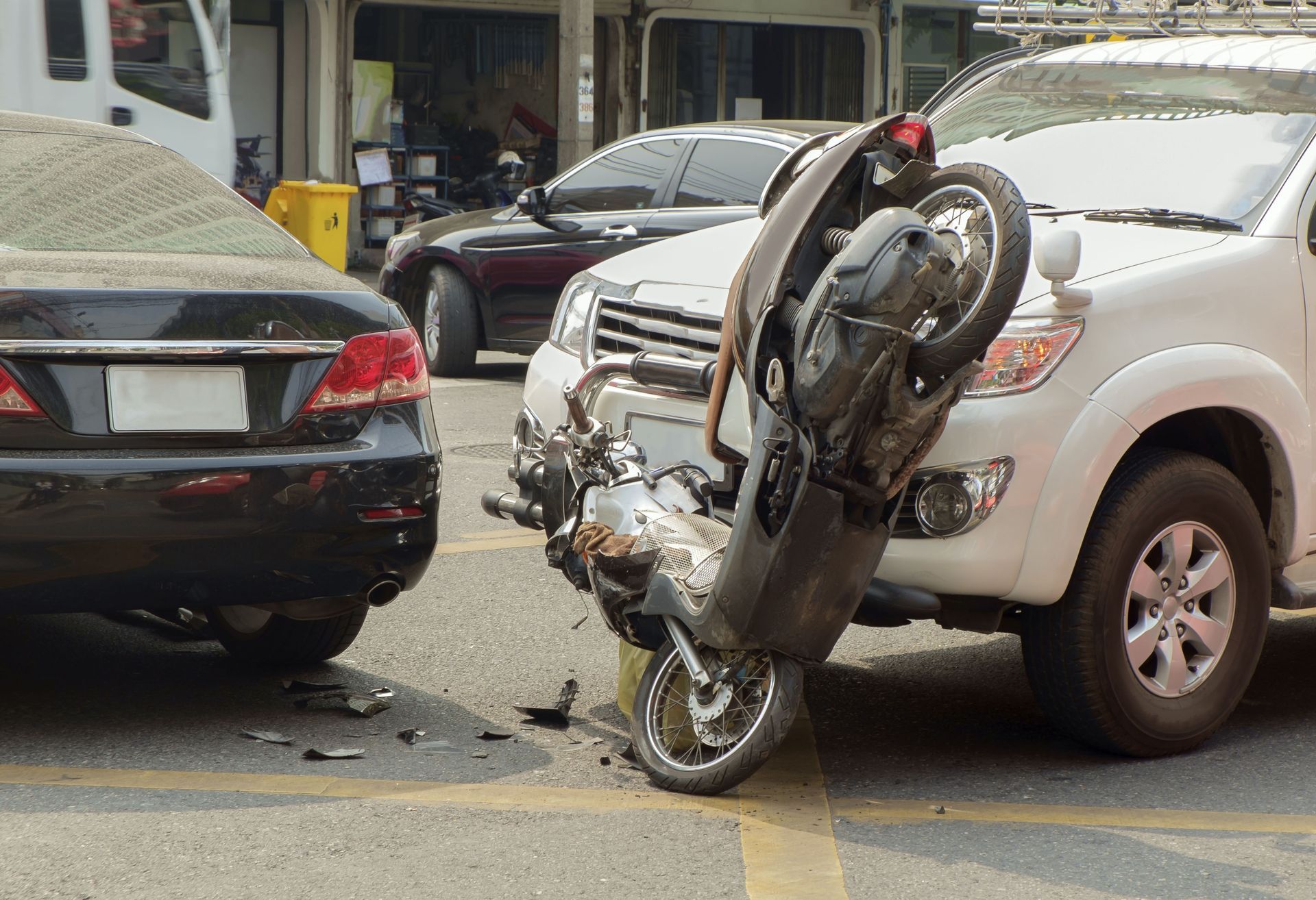A motorcycle has crashed into a car on a city street.
