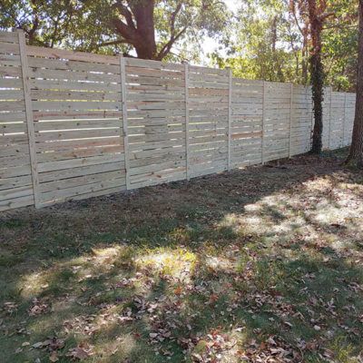 A wooden fence is sitting in the middle of a grassy field.