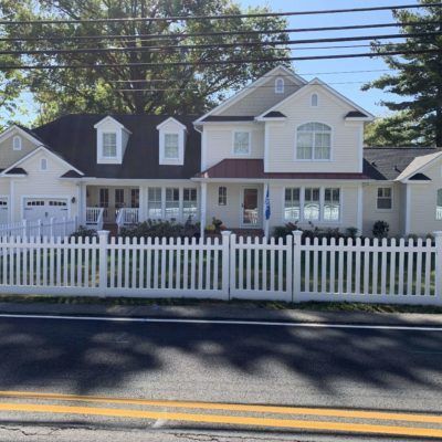 A white house with a white picket fence around it