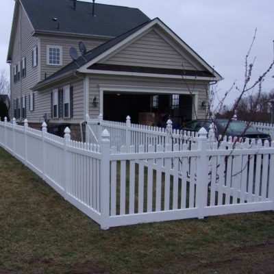 A house with a white picket fence in front of it