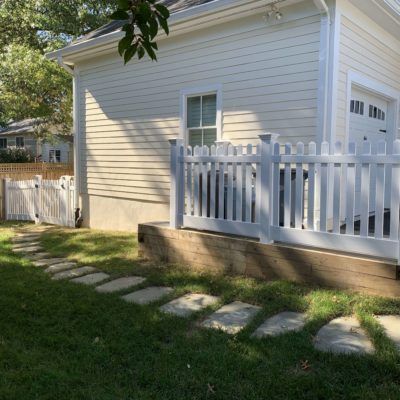 A white house with a white picket fence in front of it