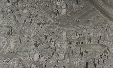 Gray stone with rough texture, possibly a quarry wall.