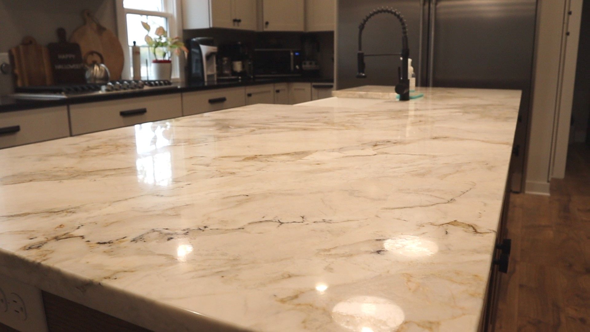 Kitchen with large marble countertop and black faucet.