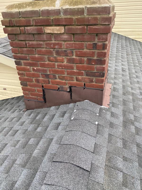 Shingle roof with brick chimney