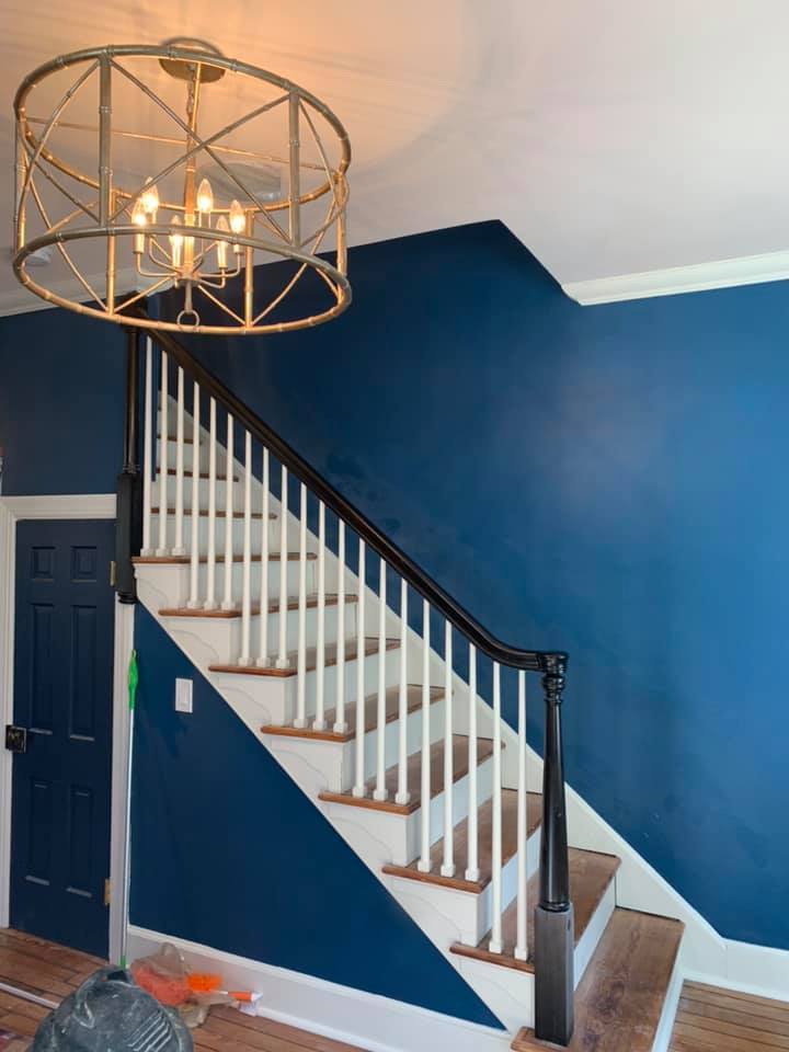 Blue colored wall and white stairs with brown railings