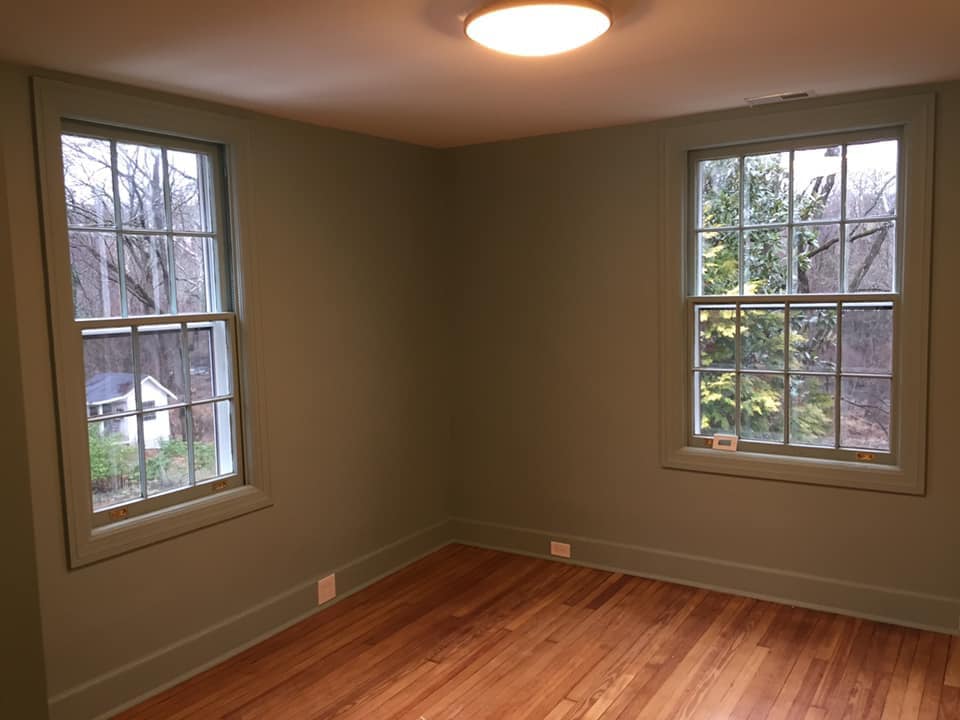 Empty room with two windows and wooden floors