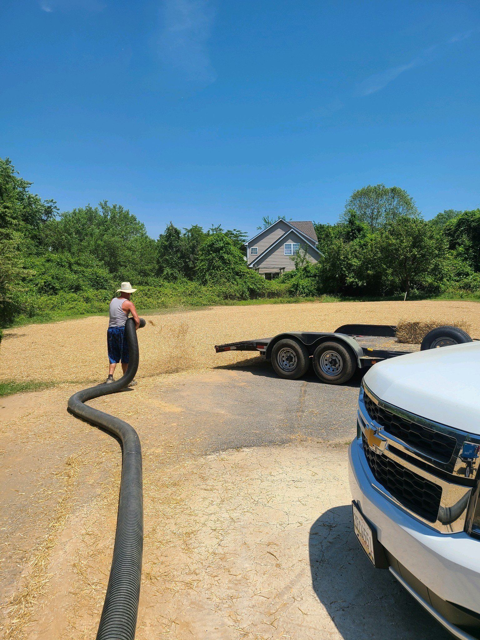 A man is standing next to a truck with a trailer attached to it.