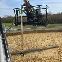 A man is standing on a platform with a hose attached to it.