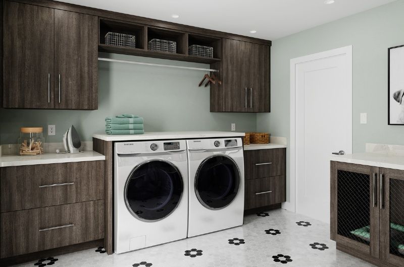 A laundry room with a washer and dryer and wooden cabinets.