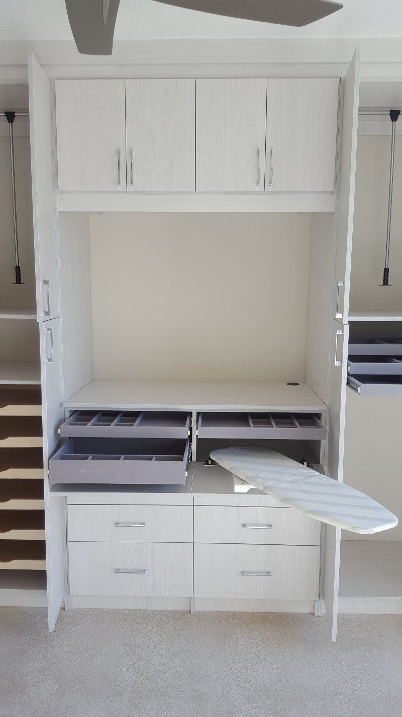 A closet with a ironing board built into it.