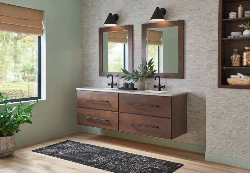 A bathroom with two sinks , two mirrors and a rug.