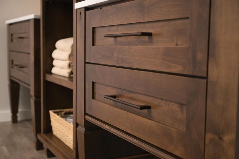 A bathroom vanity with wooden drawers and shelves filled with towels.