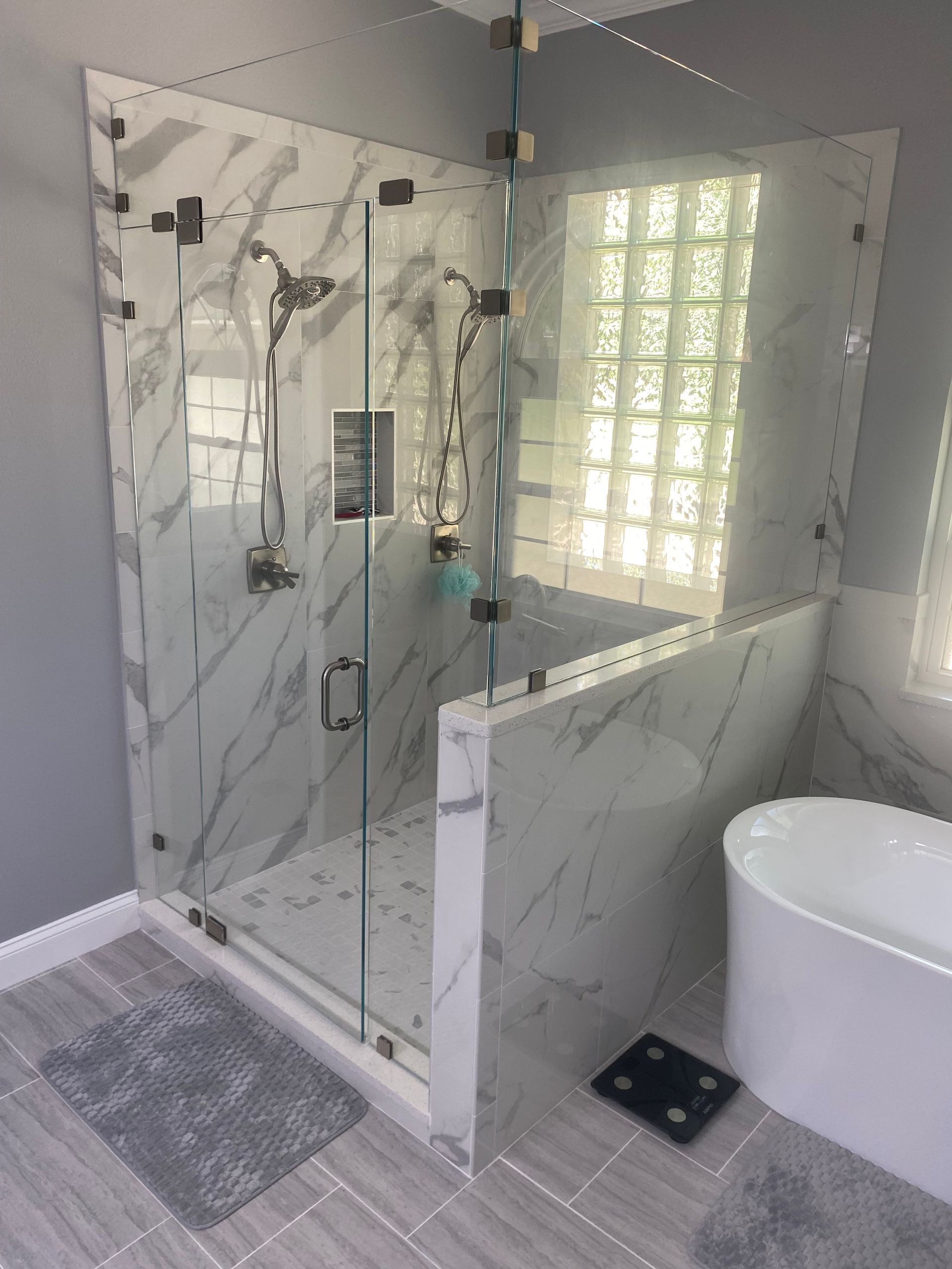 A bathroom with a walk in shower and a bathtub.