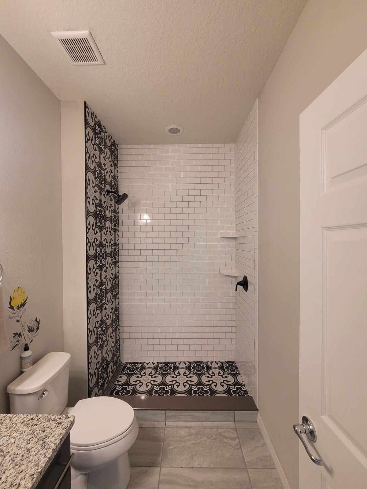 A bathroom with a toilet and a walk-in shower