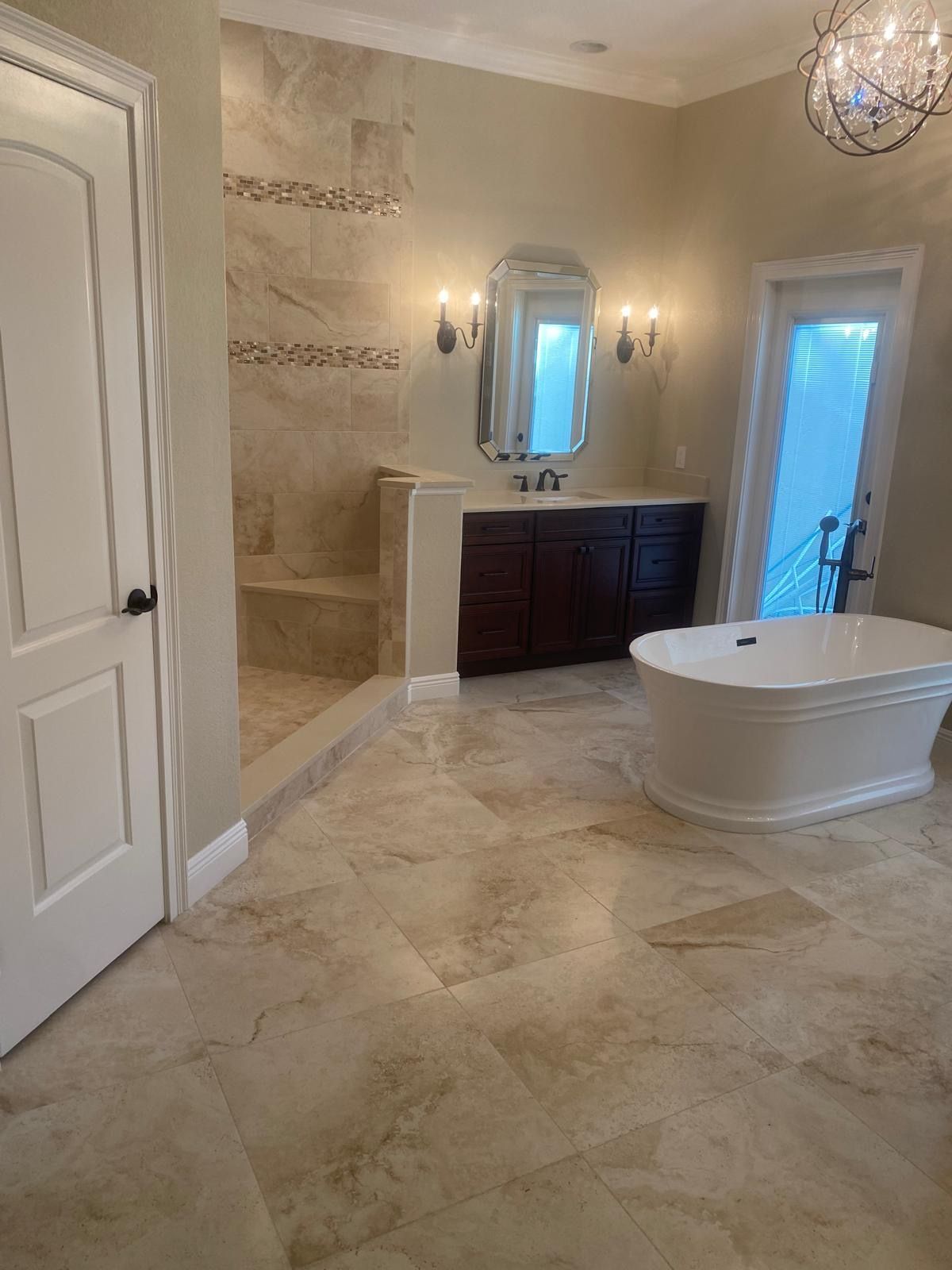 A bathroom with a tub, sink, mirror and shower