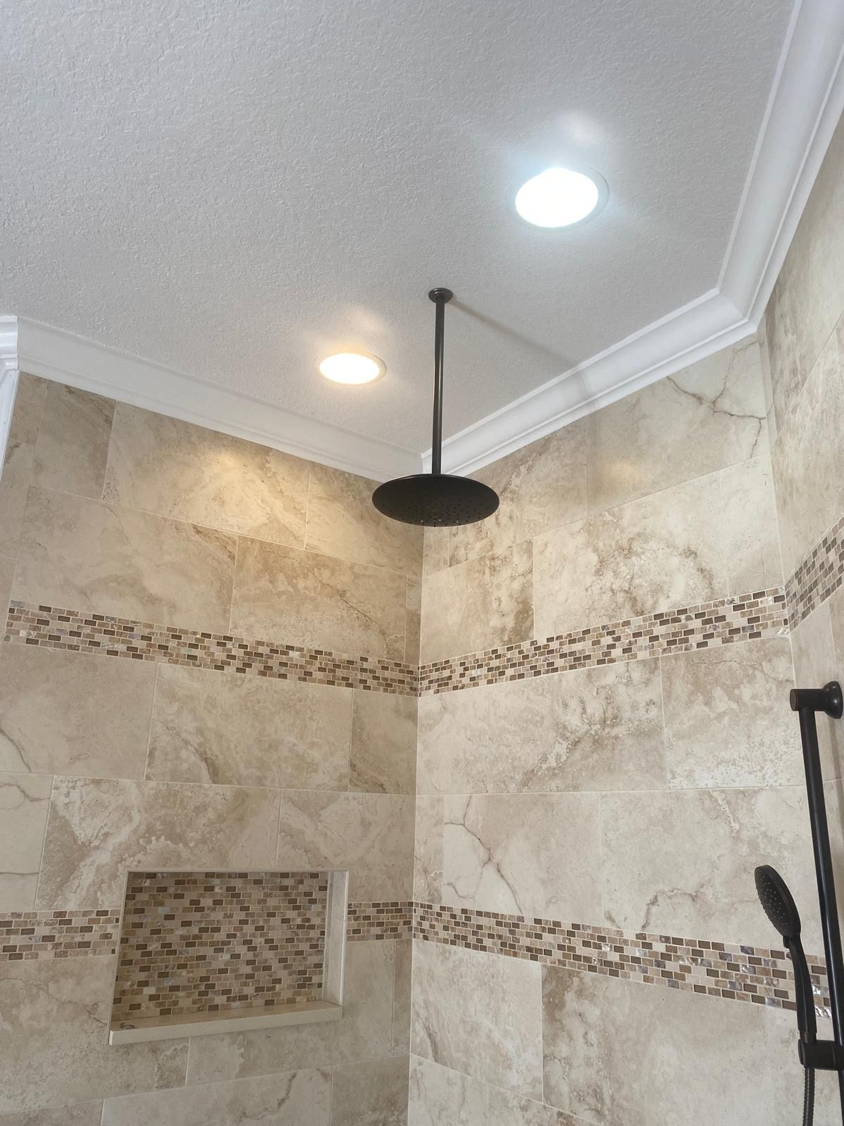 A bathroom with a shower head hanging from the ceiling