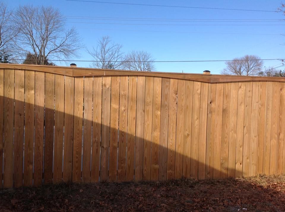 Wooden fence with a diagonal shadow under a clear blue sky