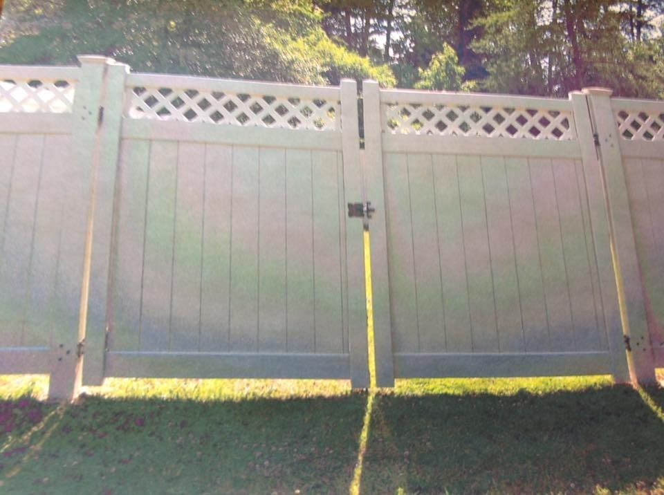 White vinyl fence with lattice top panels in a sunny yard
