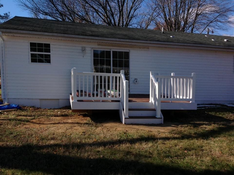 White house exterior with a small front porch and steps leading to the yard