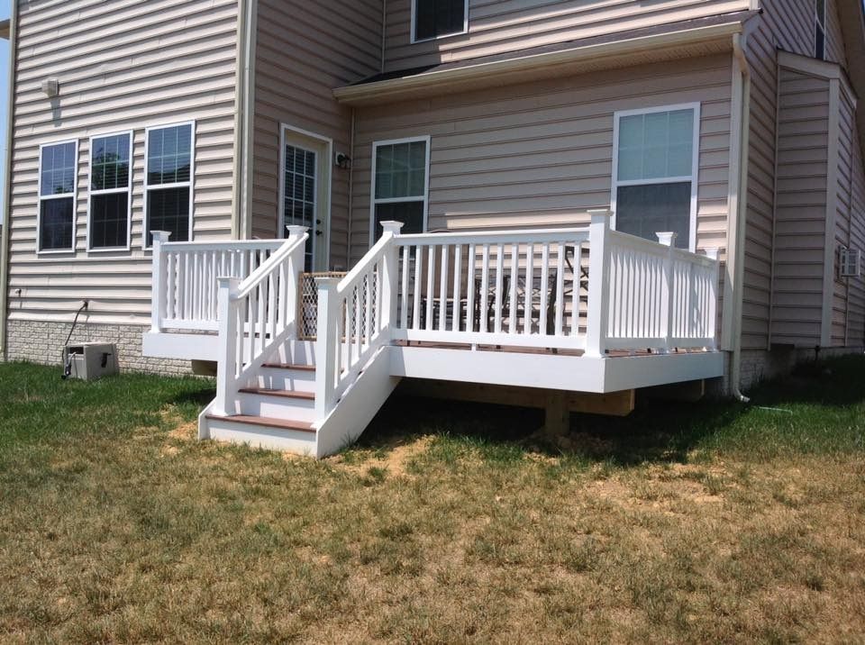House exterior with a white front porch and stairs, set on a grassy yard.