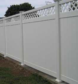 White vinyl privacy fence with lattice top along a yard boundary