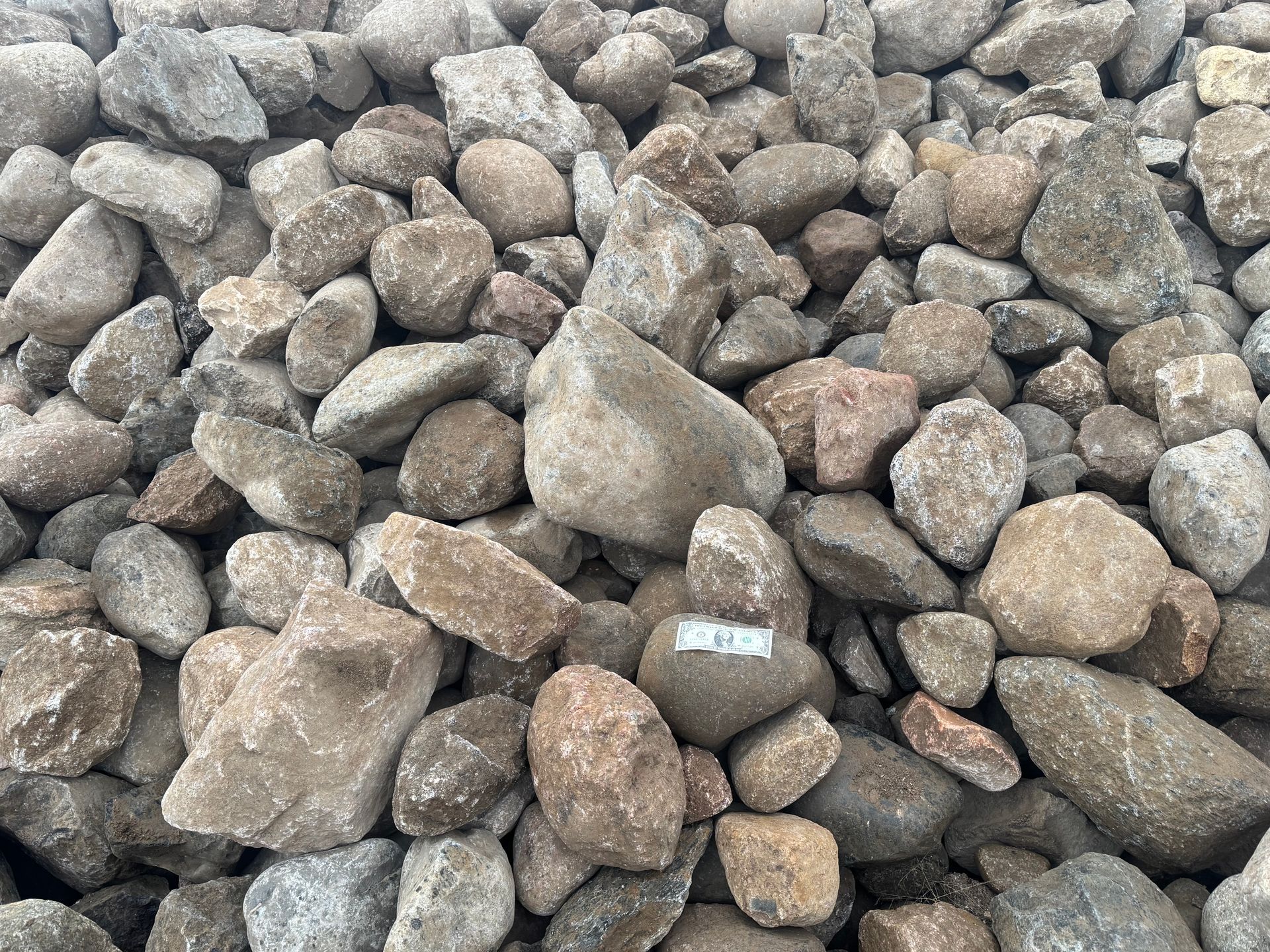 A pile of rocks sitting on top of each other on the ground.