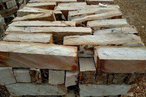 A pile of wood sitting on top of each other on the ground.