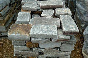 A pile of bricks sitting on top of each other on the ground.